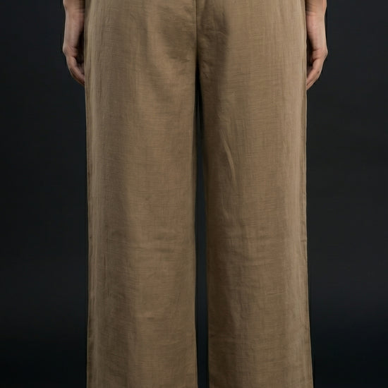 Person wearing khaki wide-leg pants on a black background