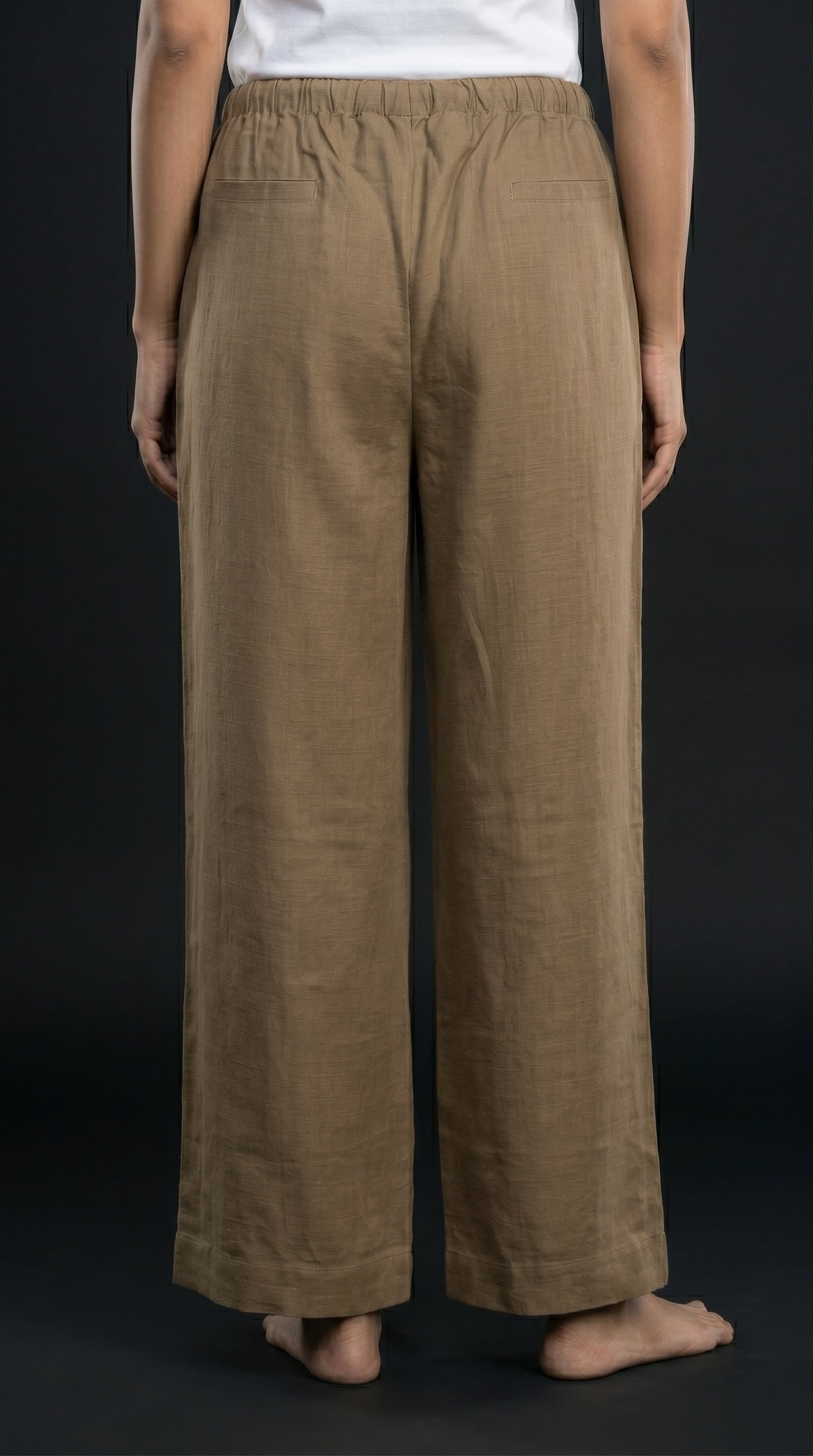 Person wearing khaki wide-leg pants on a black background
