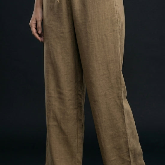 Person wearing khaki wide-leg pants on a black background